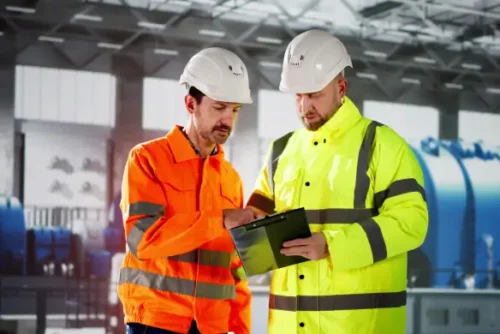 Workers with hard hats going over plans