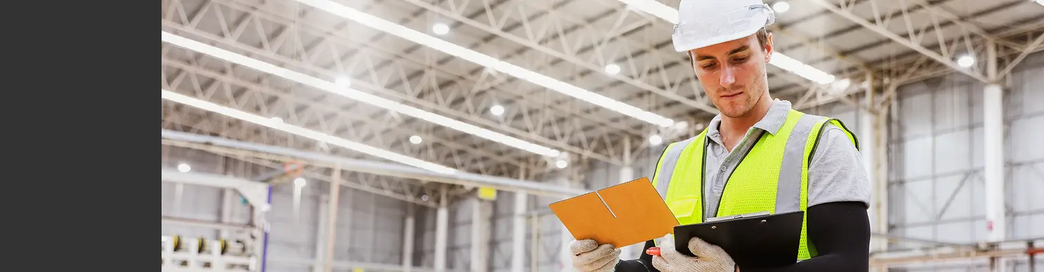 Worker checking clipboard in warehouse