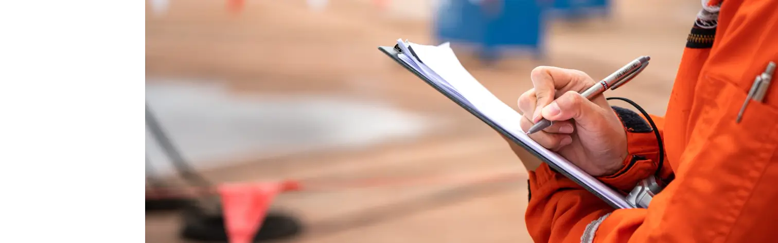 Close up of worker writing on clipboard