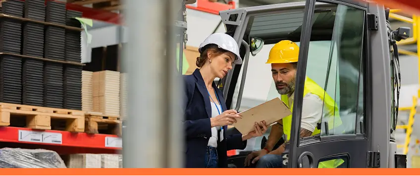 2 employees in hard hats looking at clipboard