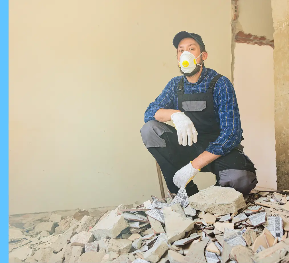 worker crouching over debris