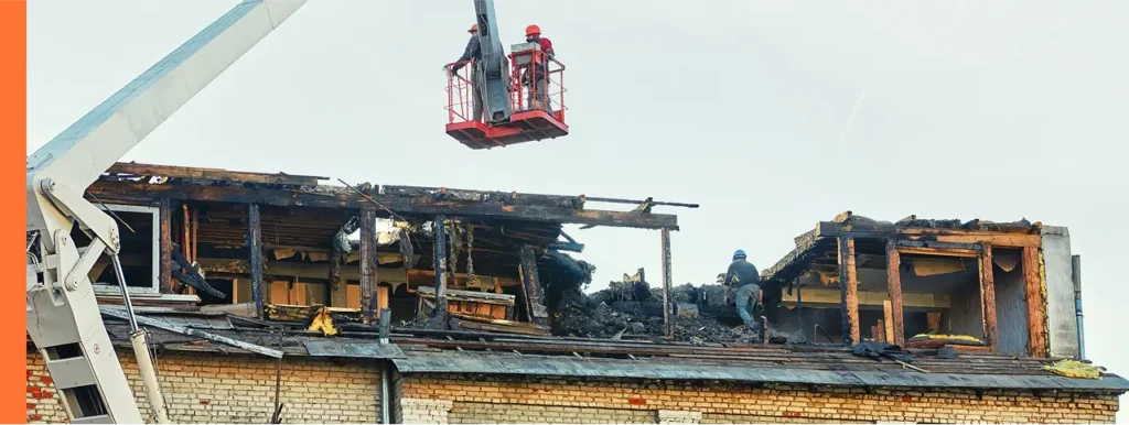 workers lifted onto roof of damage home