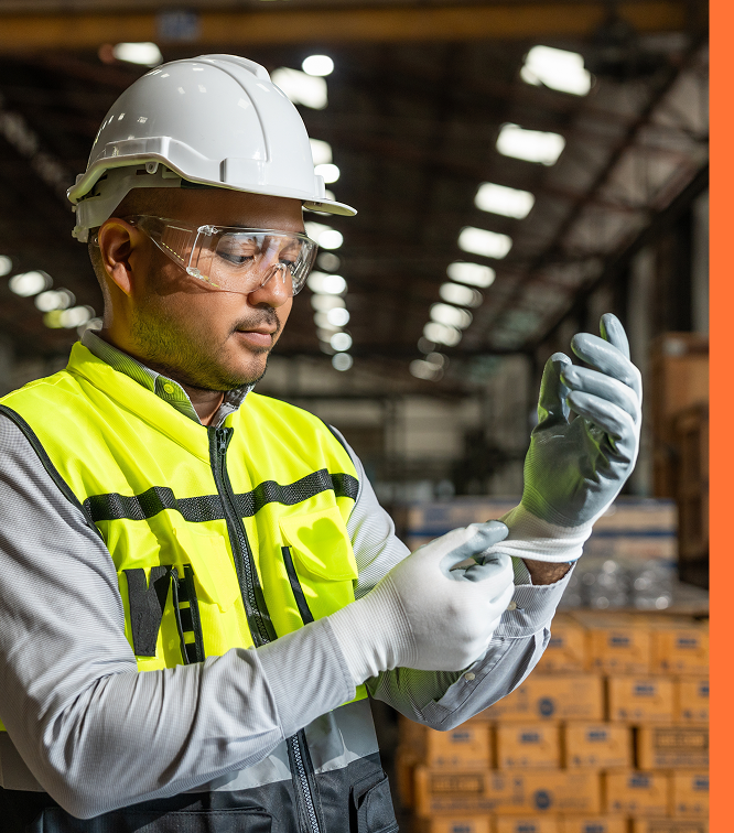 worker with hard hat putting on gloves