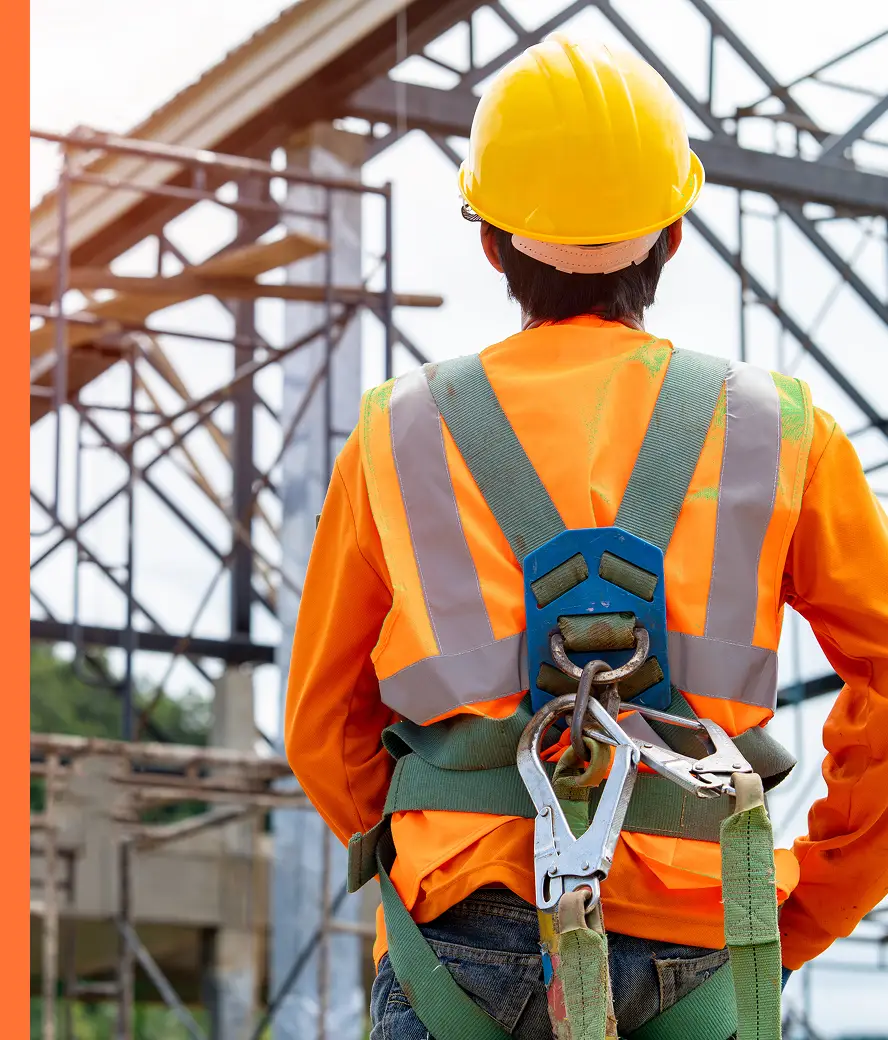 construction worker wearing orange vest and safety harness