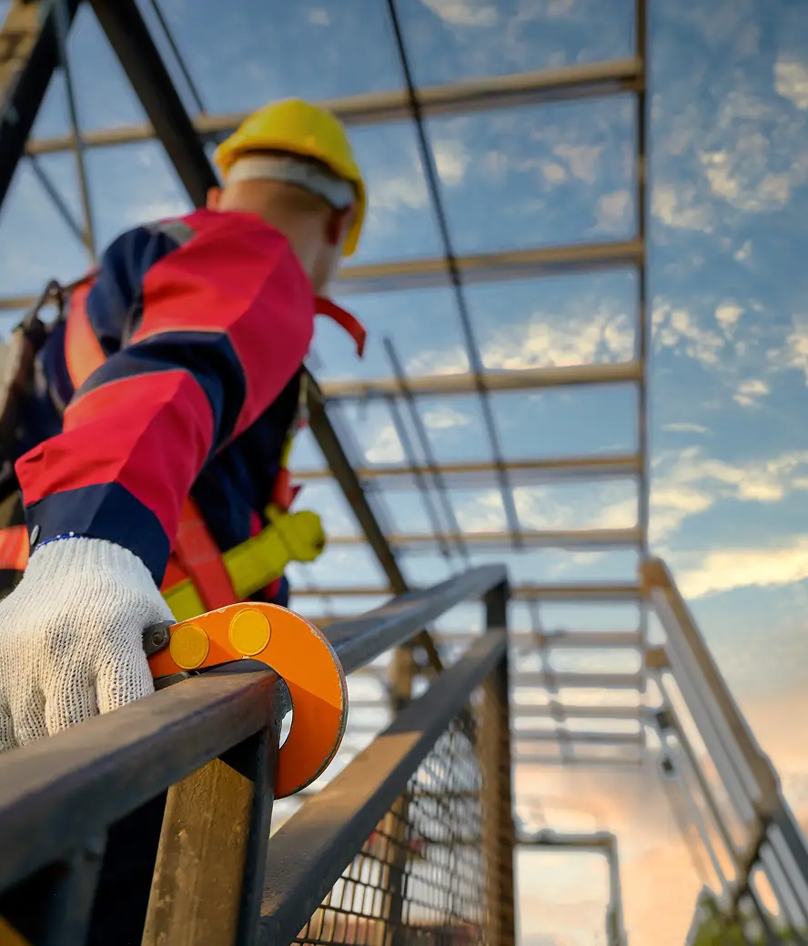 Construction worker climbing stairs holding safety line